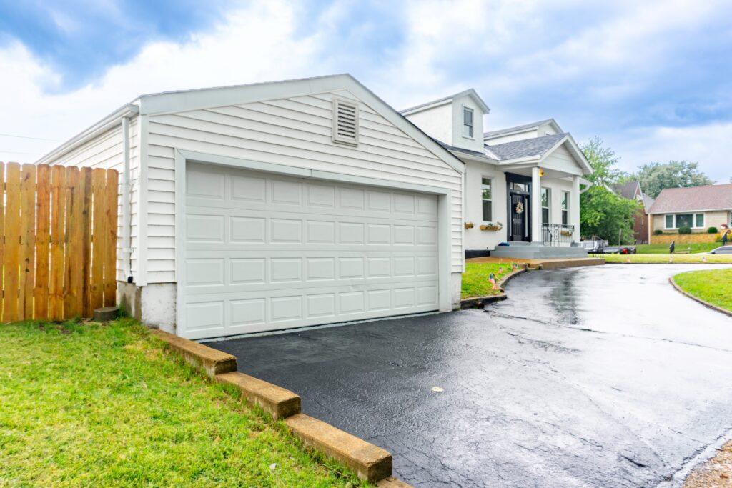 Detached two-car garage with paved driveway and fenced backyard