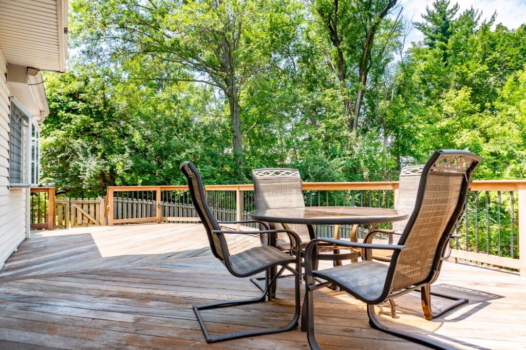 Wooden deck with outdoor table and chairs overlooking trees