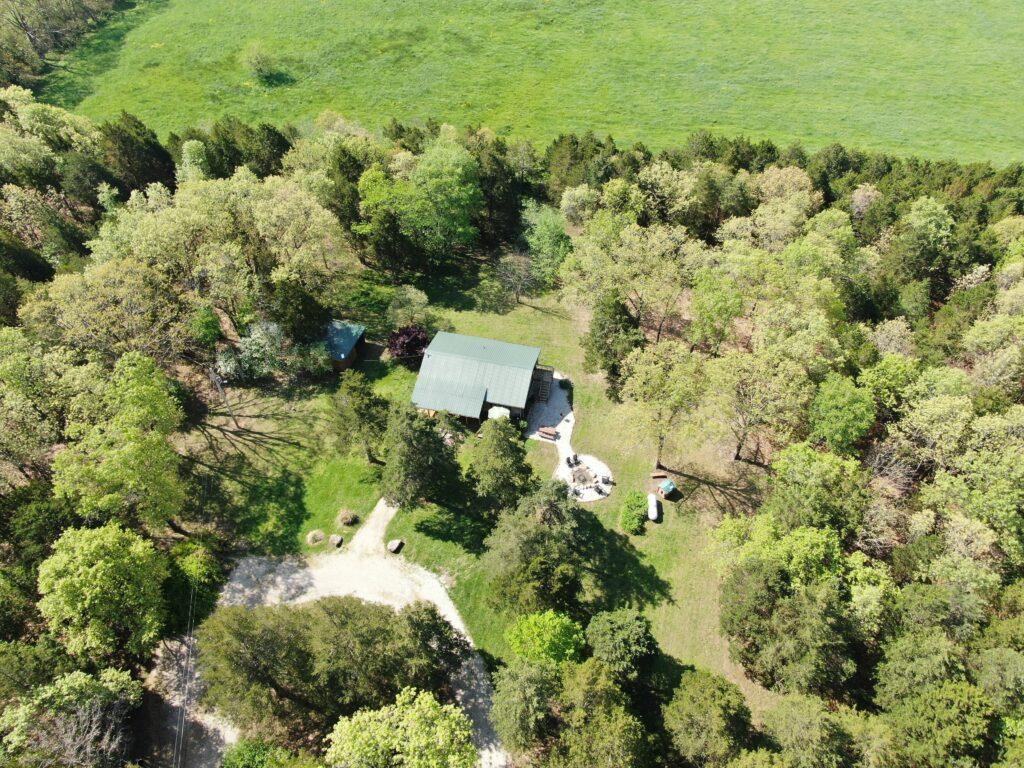 Aerial view of wooded property with home and surrounding trees