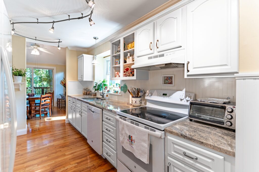 Kitchen with white cabinets, stove, and granite countertops