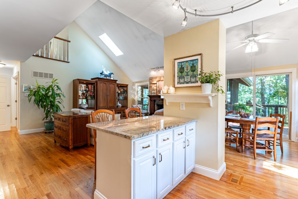 Kitchen with center island, white cabinets, and wood floors