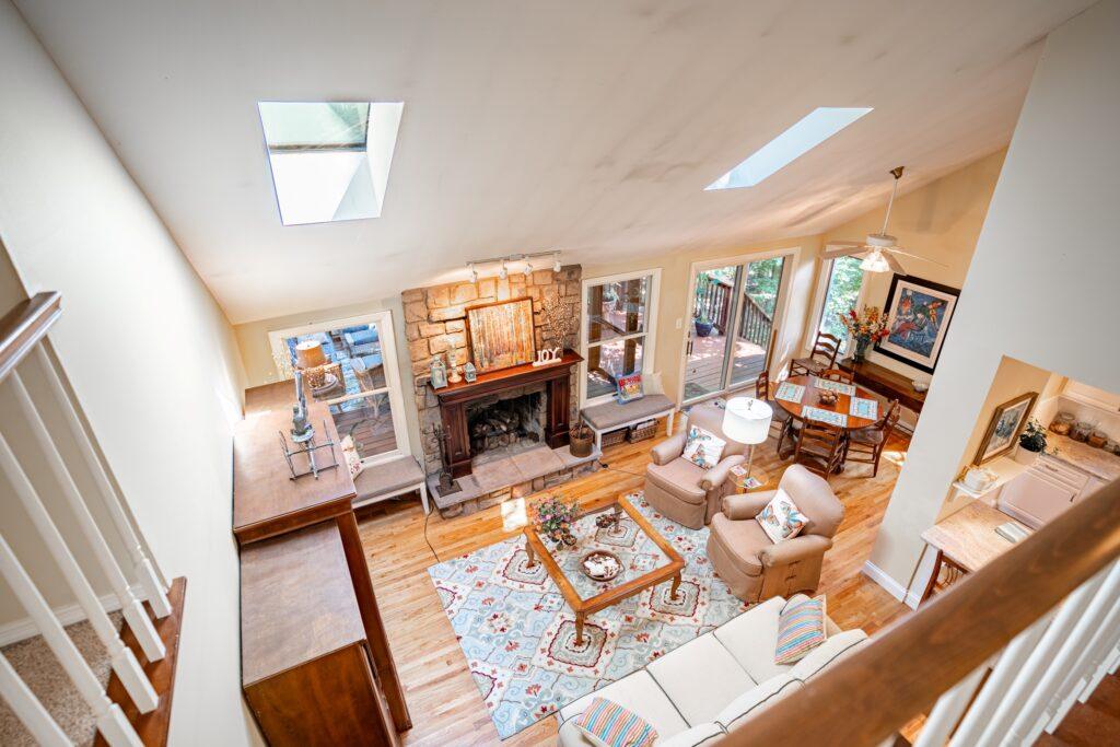 Open living area with skylights, seating, and wood flooring