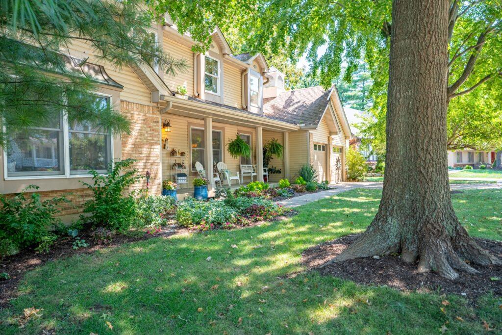 Home exterior with large shade trees and landscaped front yard
