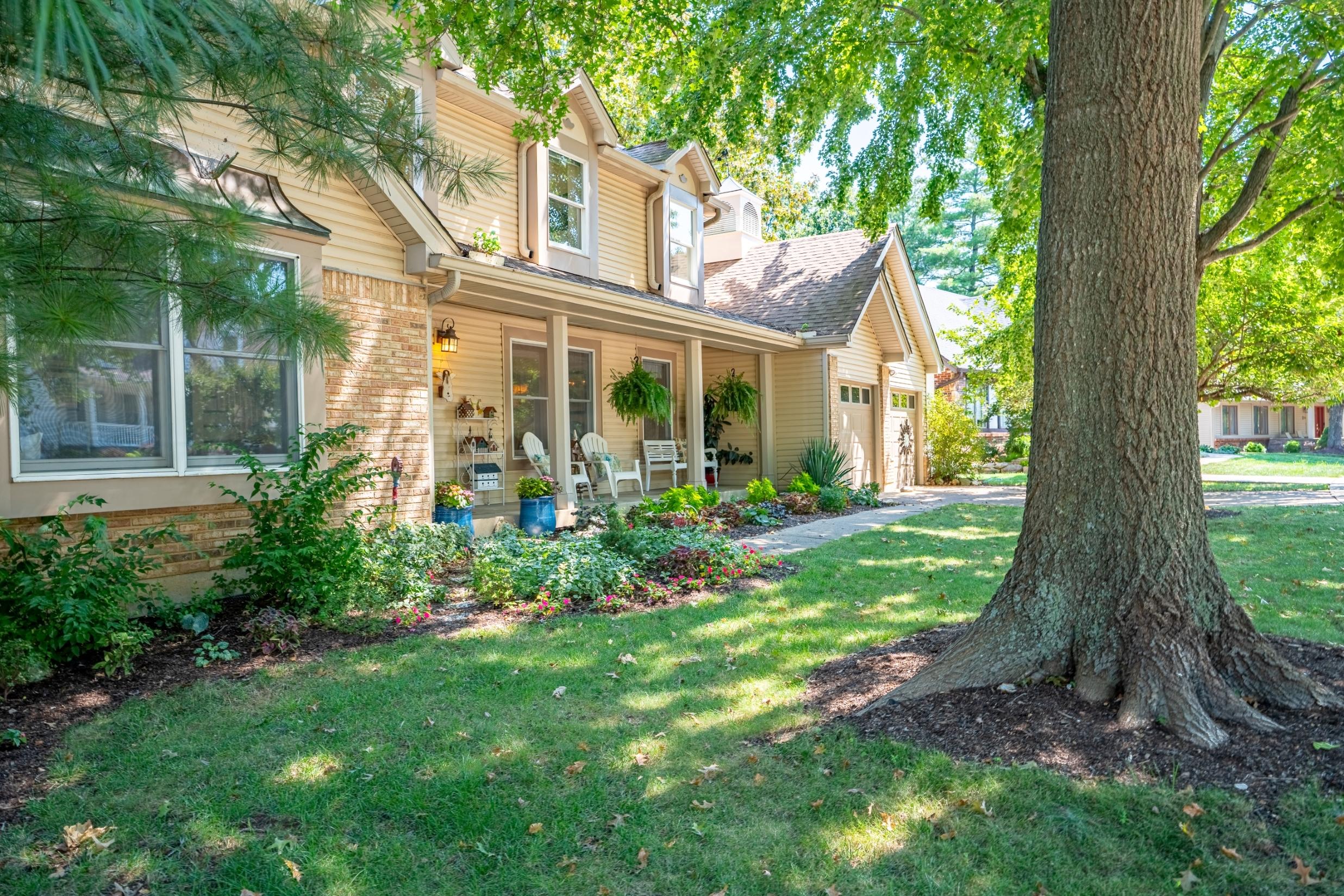 Home exterior with large shade trees and landscaped front yard