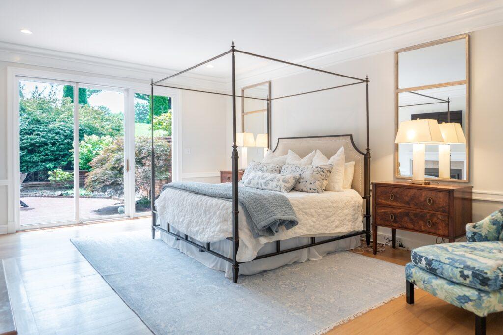 Primary bedroom with canopy bed and neutral decor