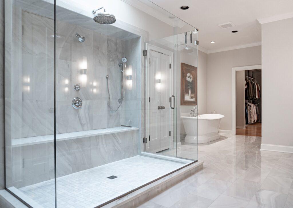 Bathroom with glass walk-in shower and marble tile walls