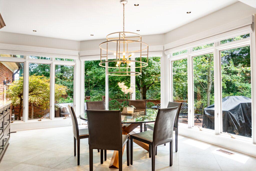 Sunroom dining area with large windows and woo