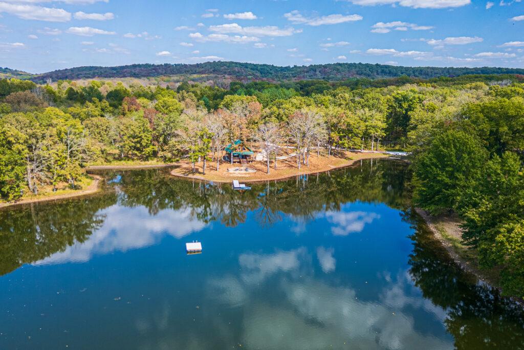 Aerial view of lake surrounded by trees and rural landscape
