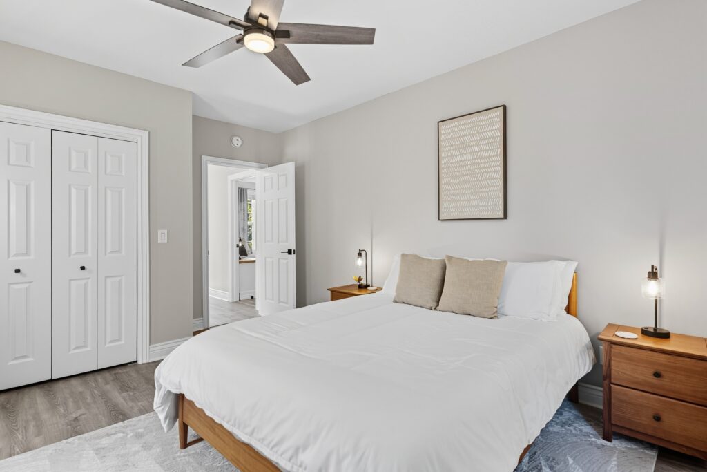 Primary bedroom with king bed, ceiling fan, and neutral decor