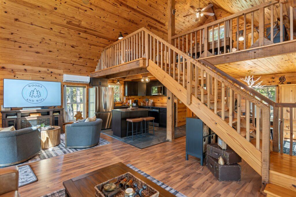 Open concept log cabin interior with kitchen, dining, and living areas