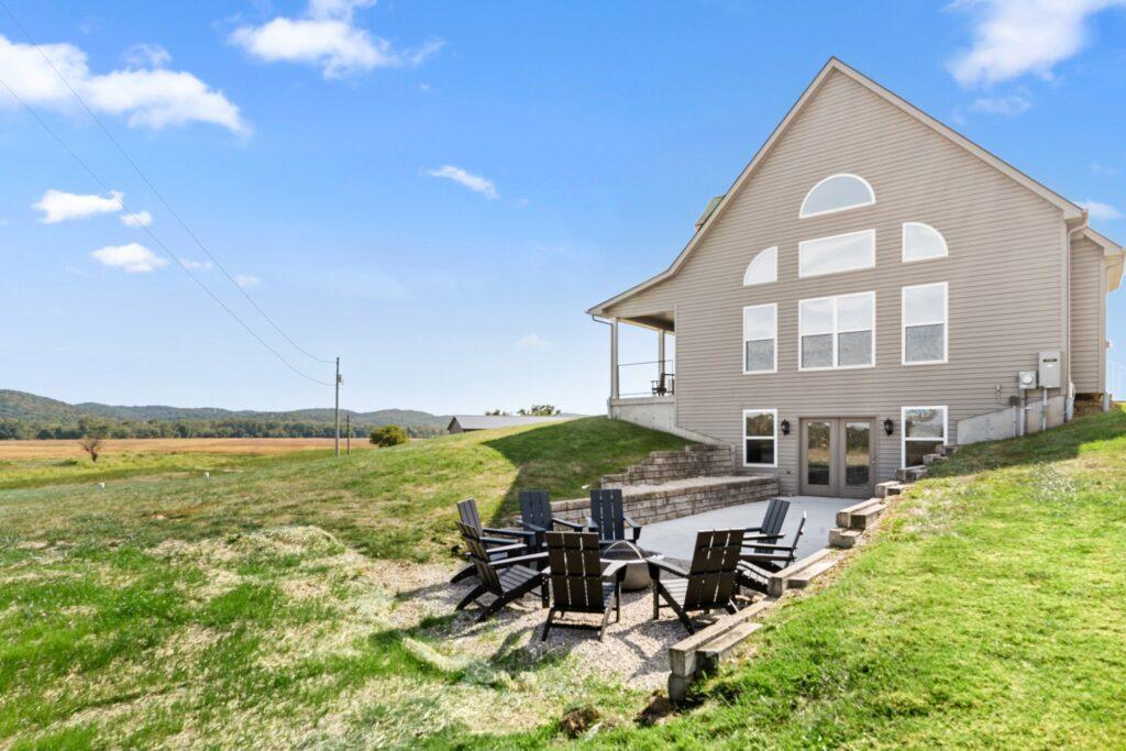 Rear exterior of home with patio seating and grassy yard
