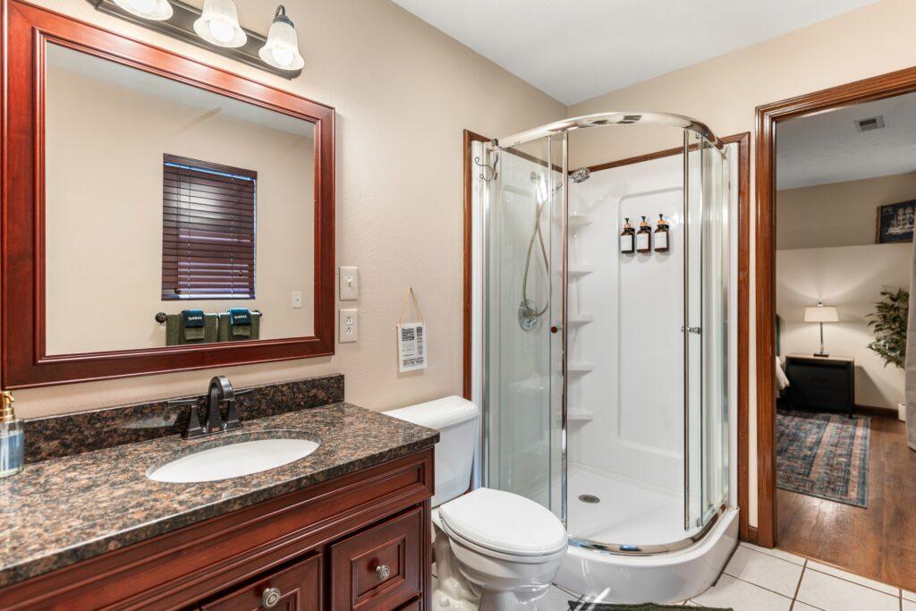 Bathroom with a stand-up shower and granite countertop sink