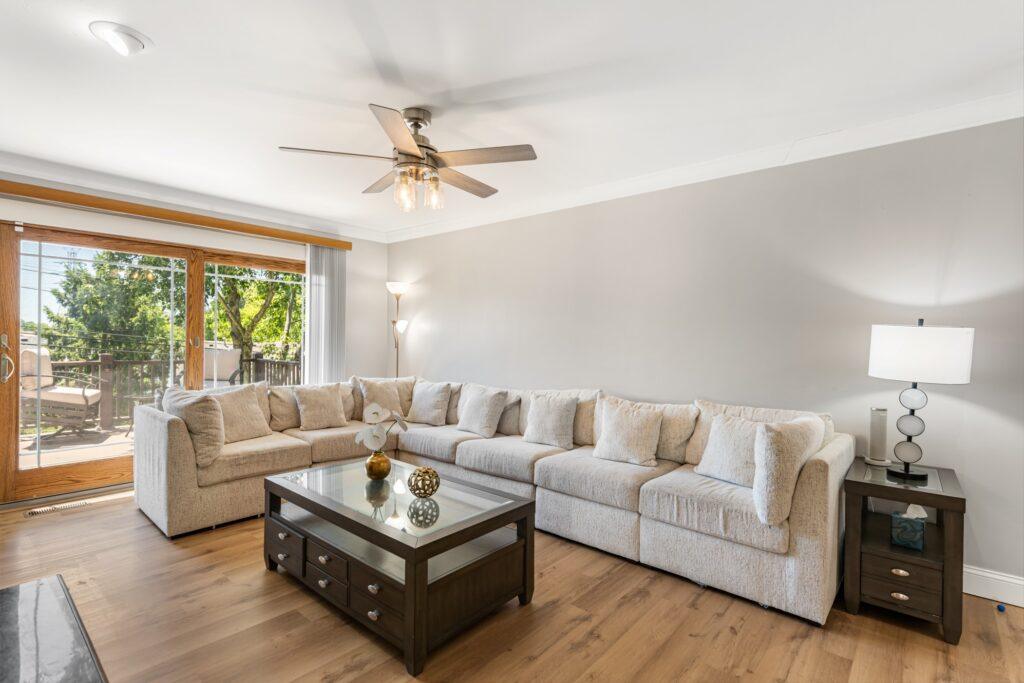 Living room with a long sectional, a coffee table, and a sliding door along the far wall