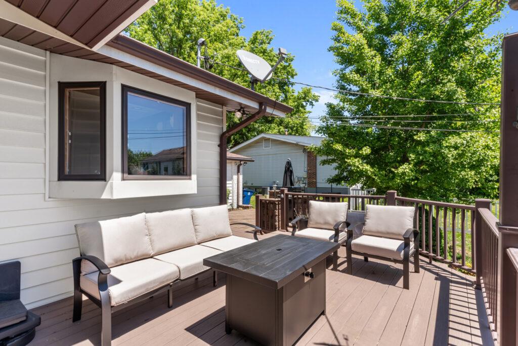 Porch with an outdoor couch, two chairs, and a coffee table