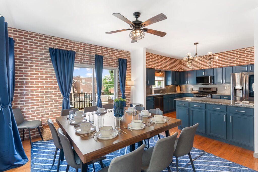 A dining room / itchen with brick walls and blue accents.
