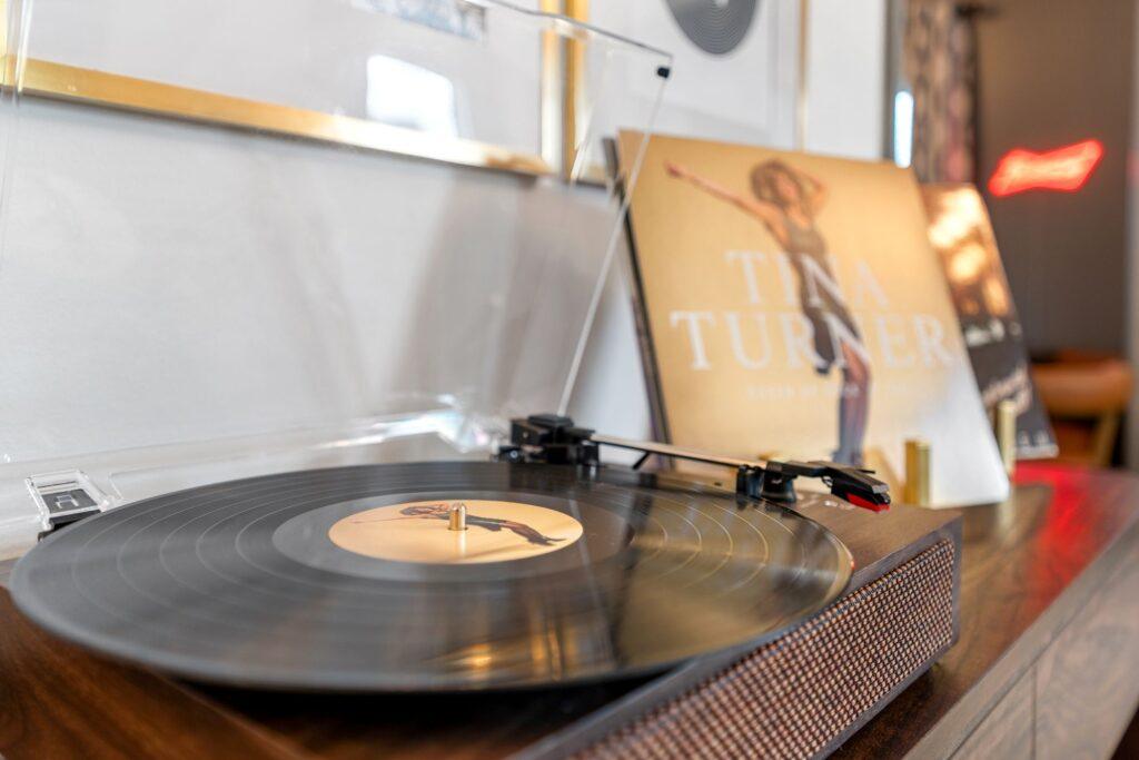 A close up photo of a record on a turntable with its sleeve in the background