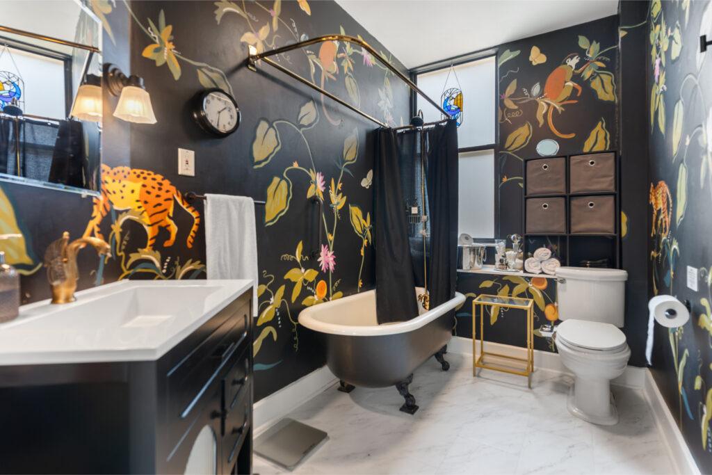 A bathroom with decorative wallpaper and vintage features