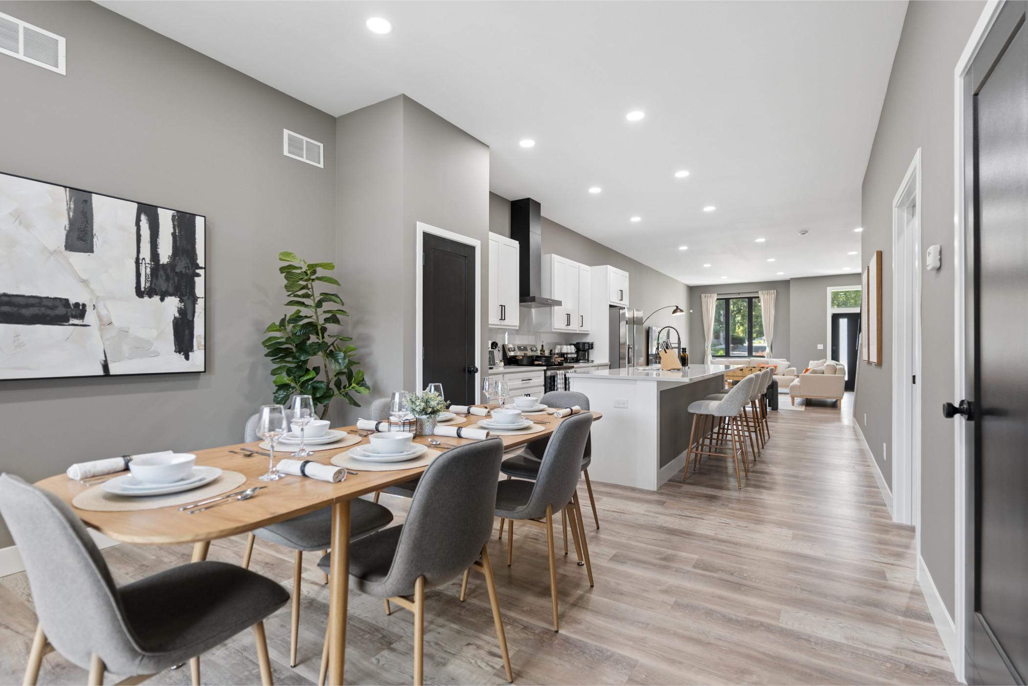 Long dining room / kitchen with a table set for six
